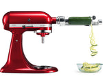 Red stand mixer with a spiralizer attachment creating zucchini noodles.